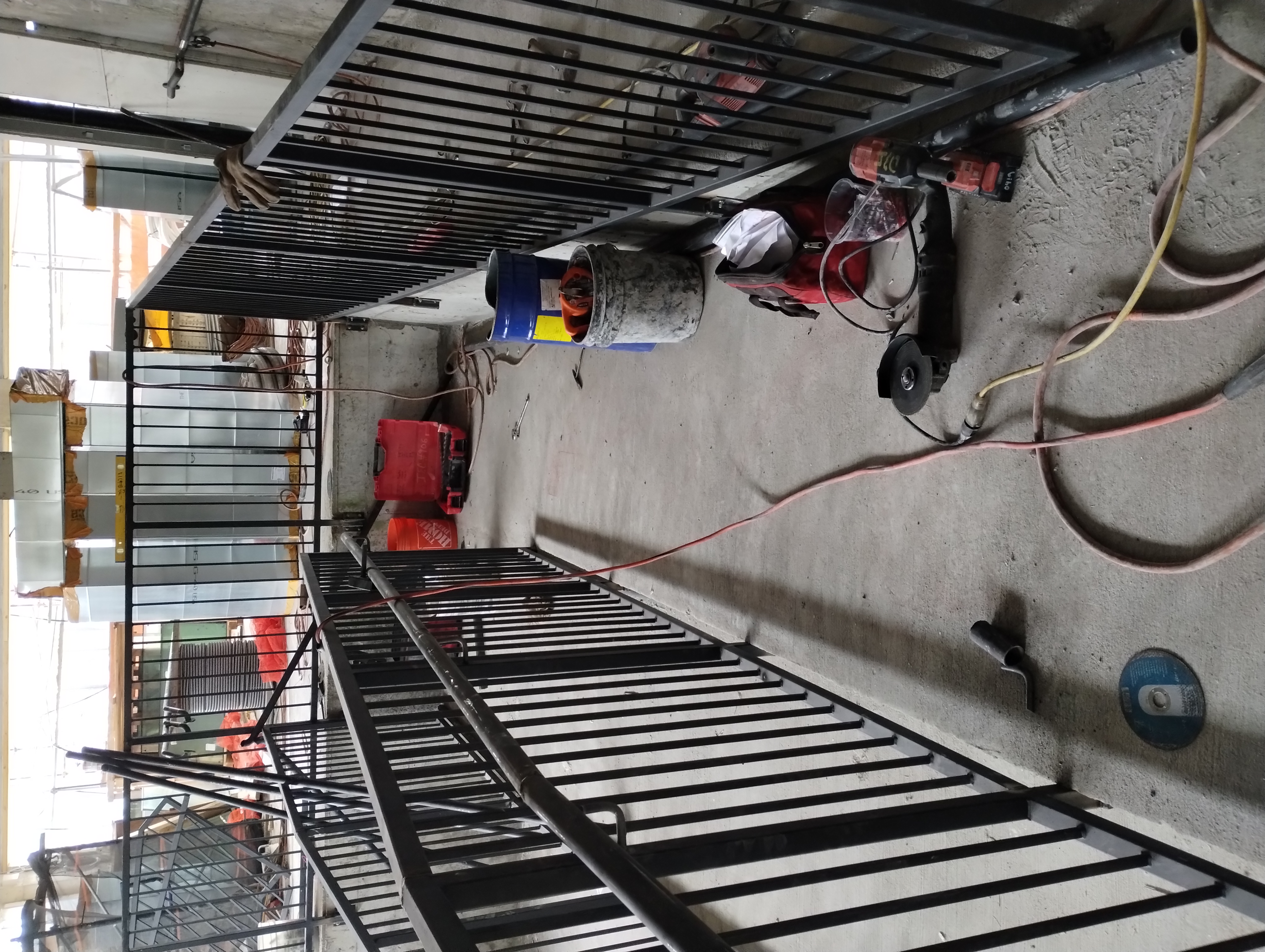 Black steel guardrails and tubular handrails around an interior stair landing
