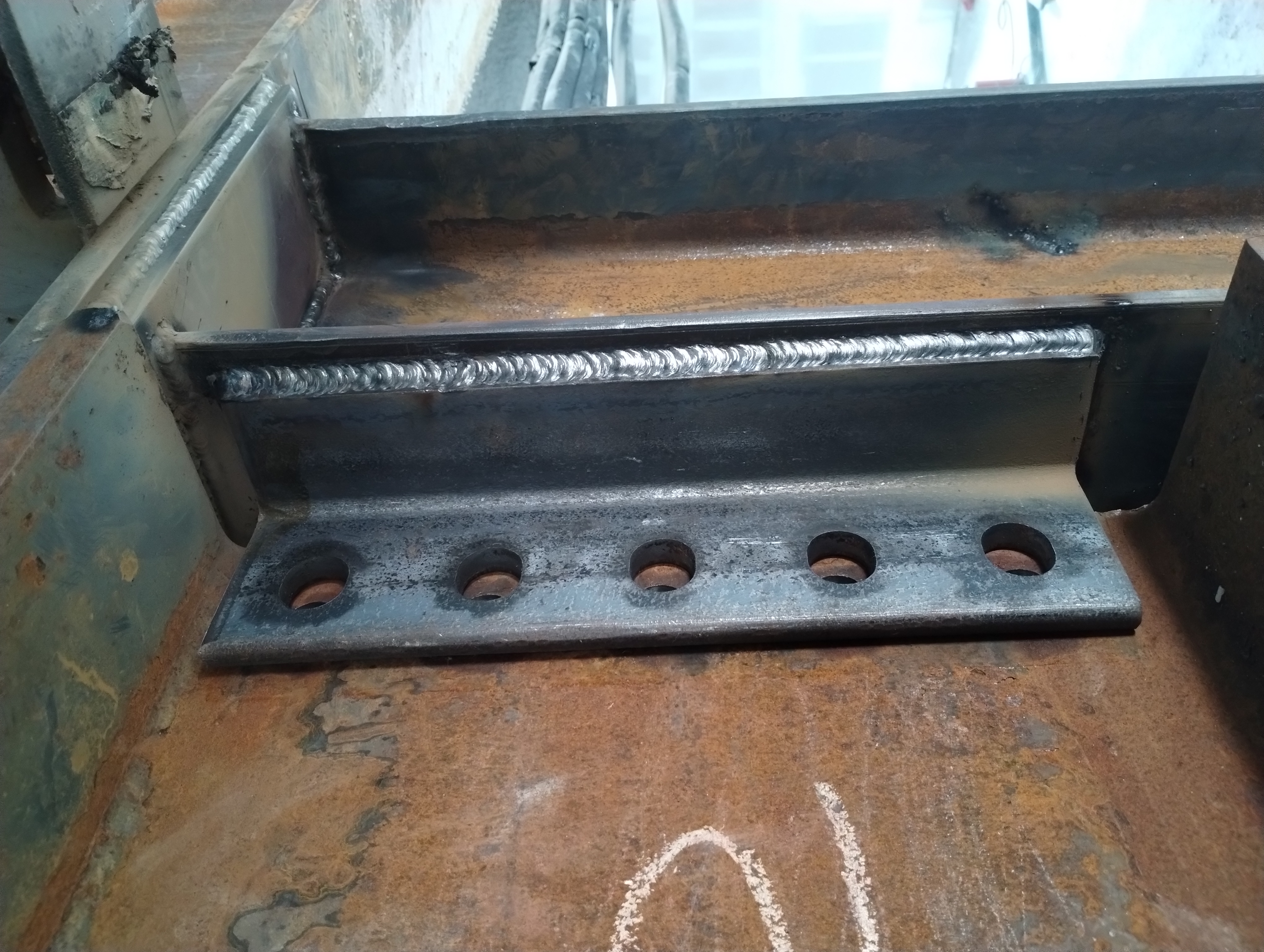 Close-up of welds joining a drilled connection plate to a steel member