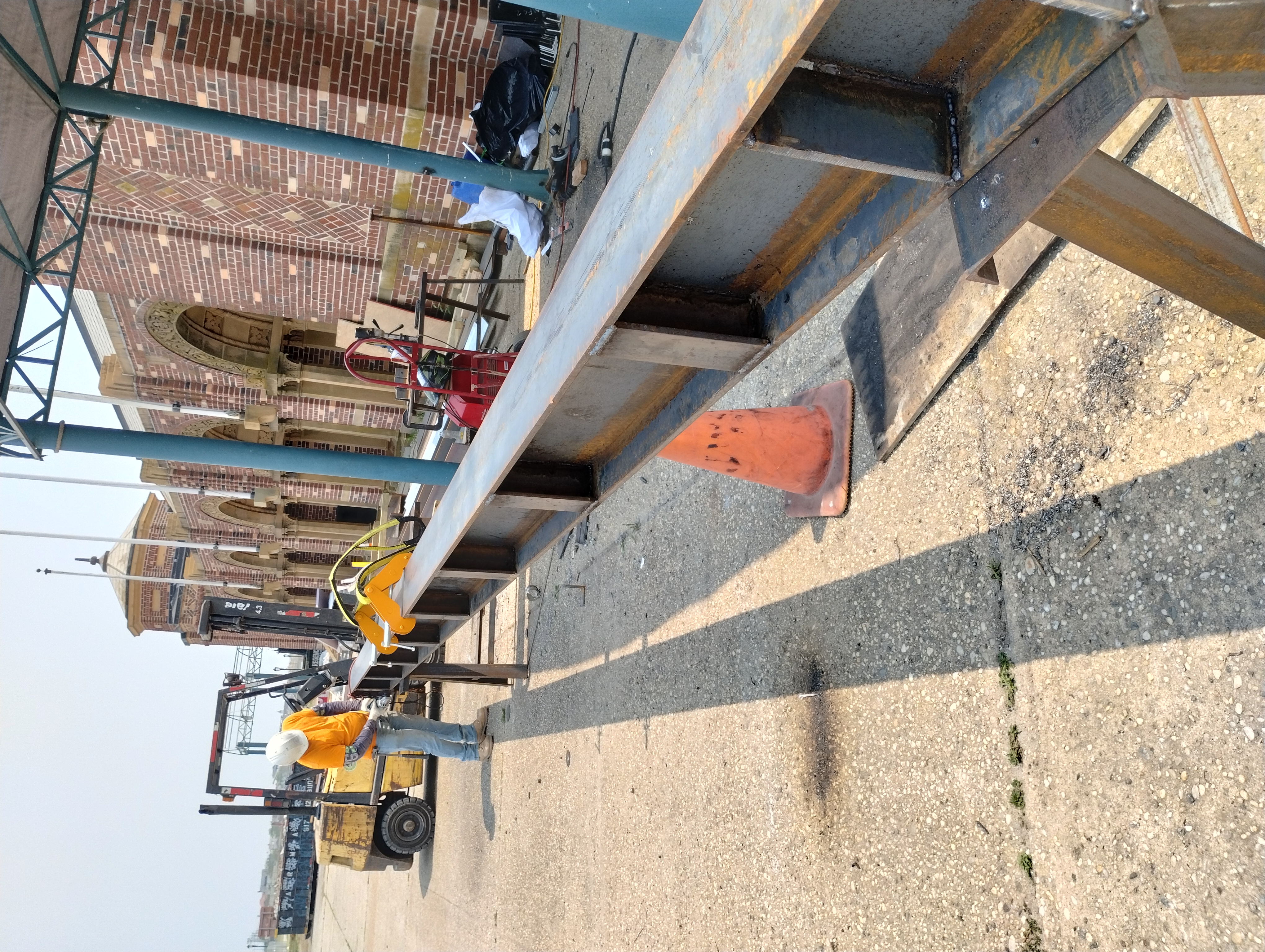 Worker and lifting equipment beside a fabricated steel beam