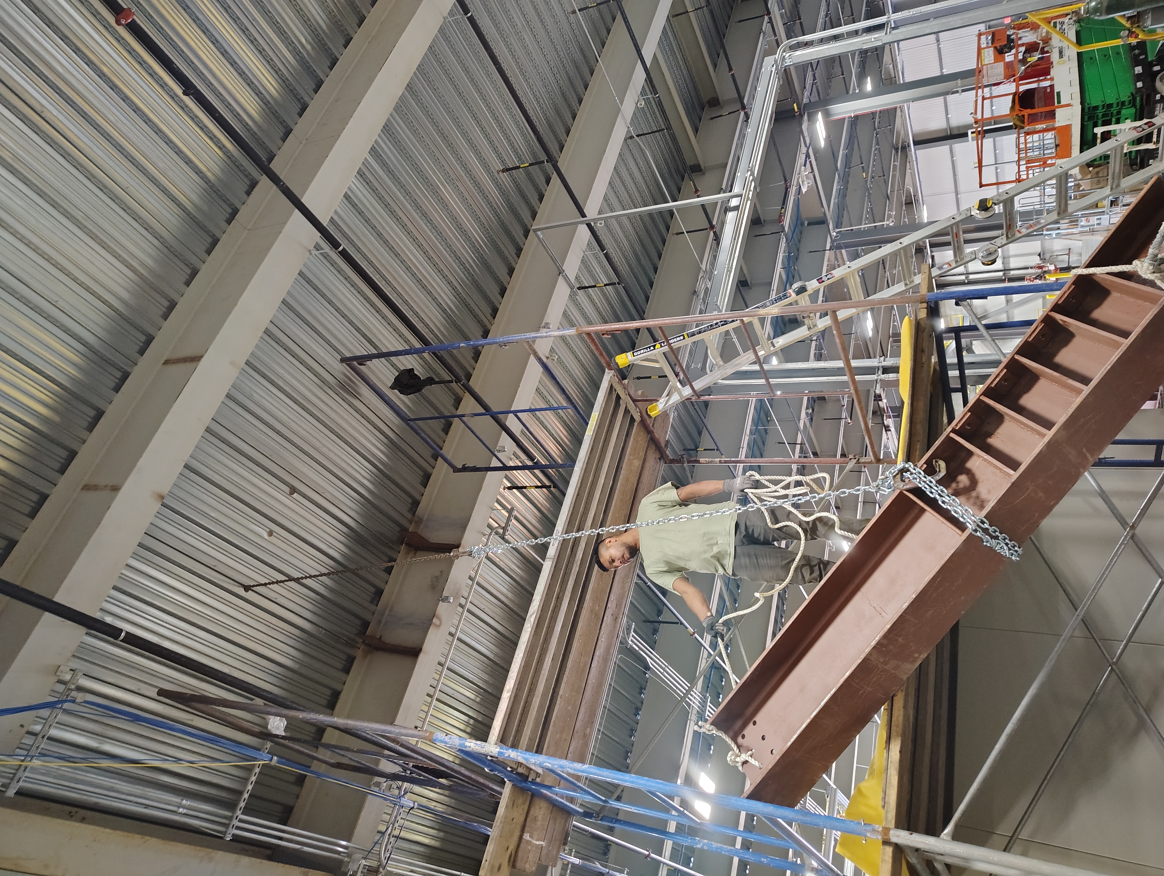 Steel beam being lifted into position inside an industrial building