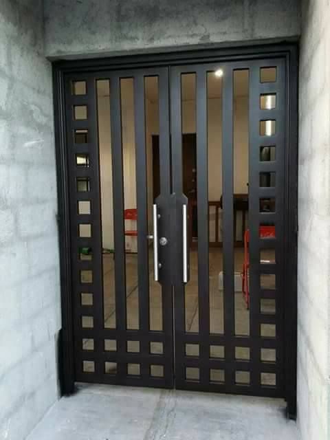 Dark double entrance gate with vertical panels and square accents