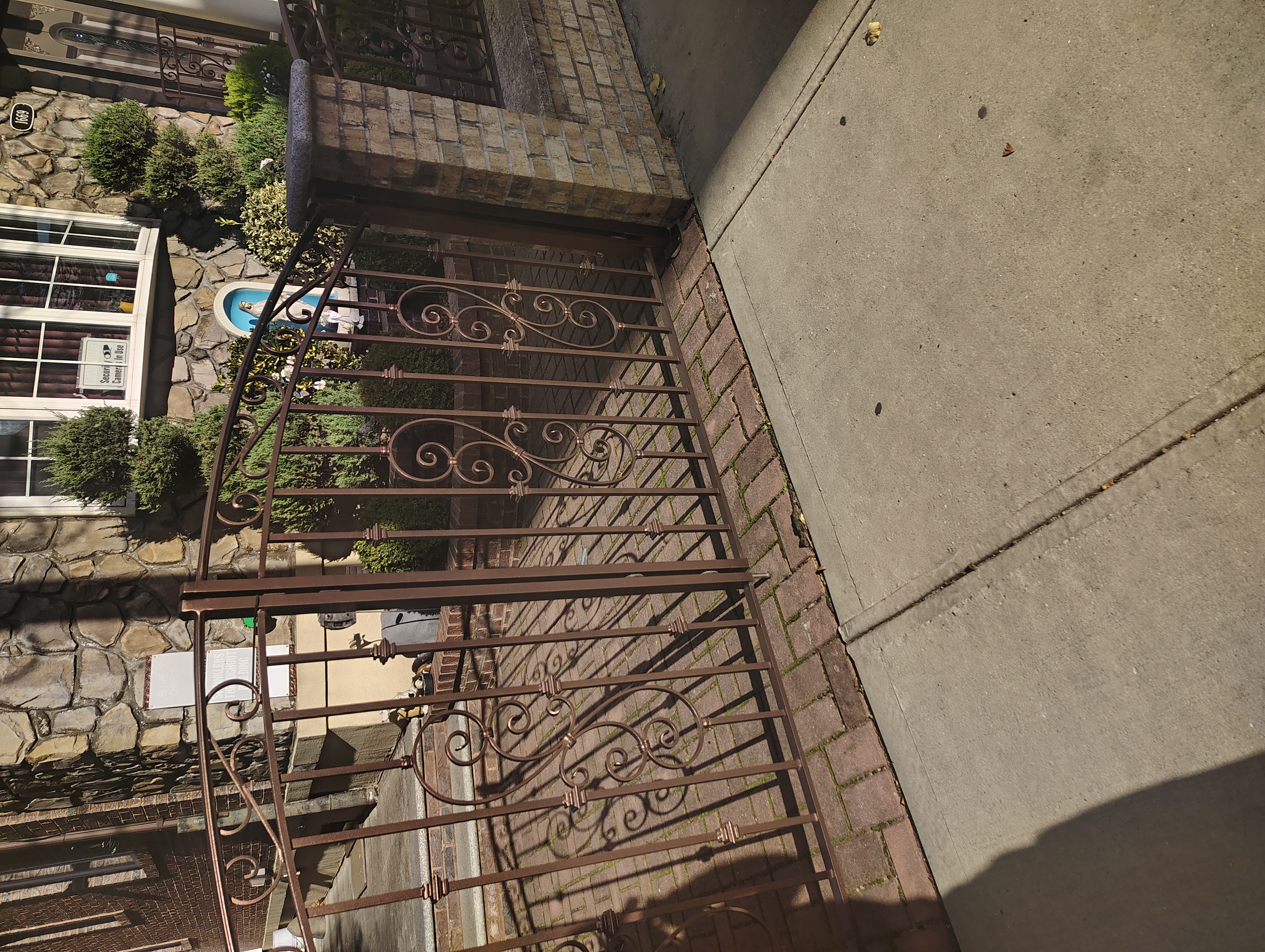 Curved driveway gates with scrollwork and decorative collars