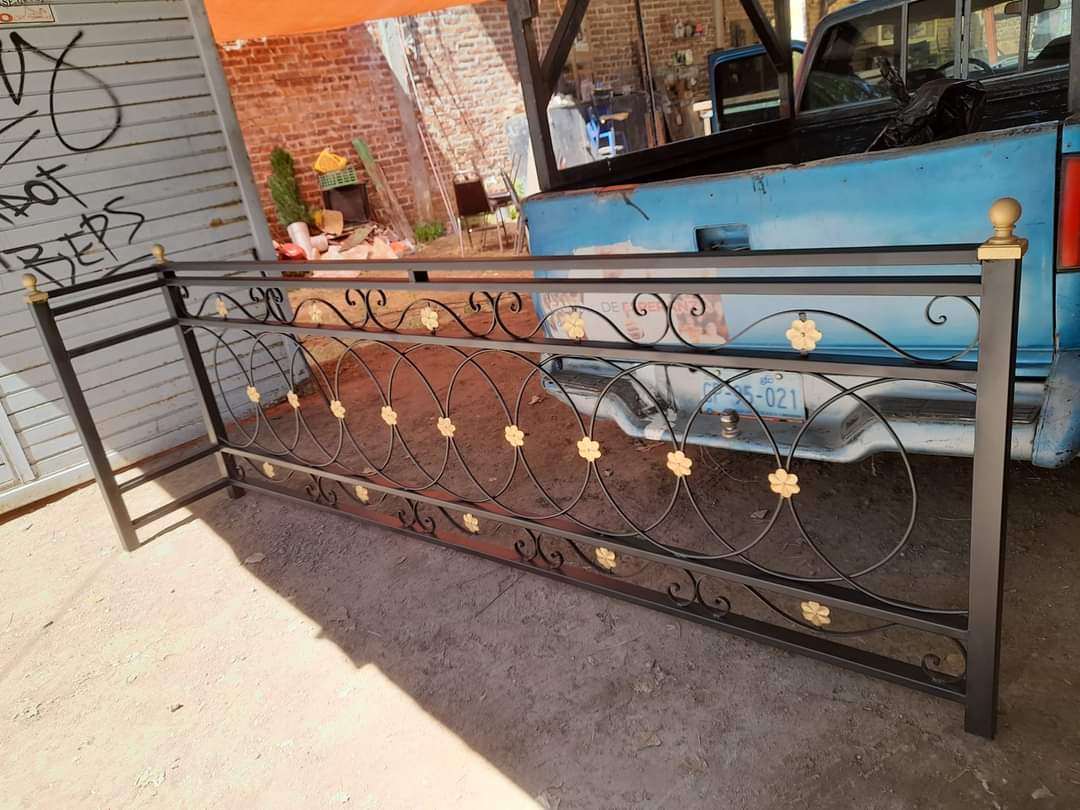 Dark decorative railing with gold-colored floral accents in a workshop