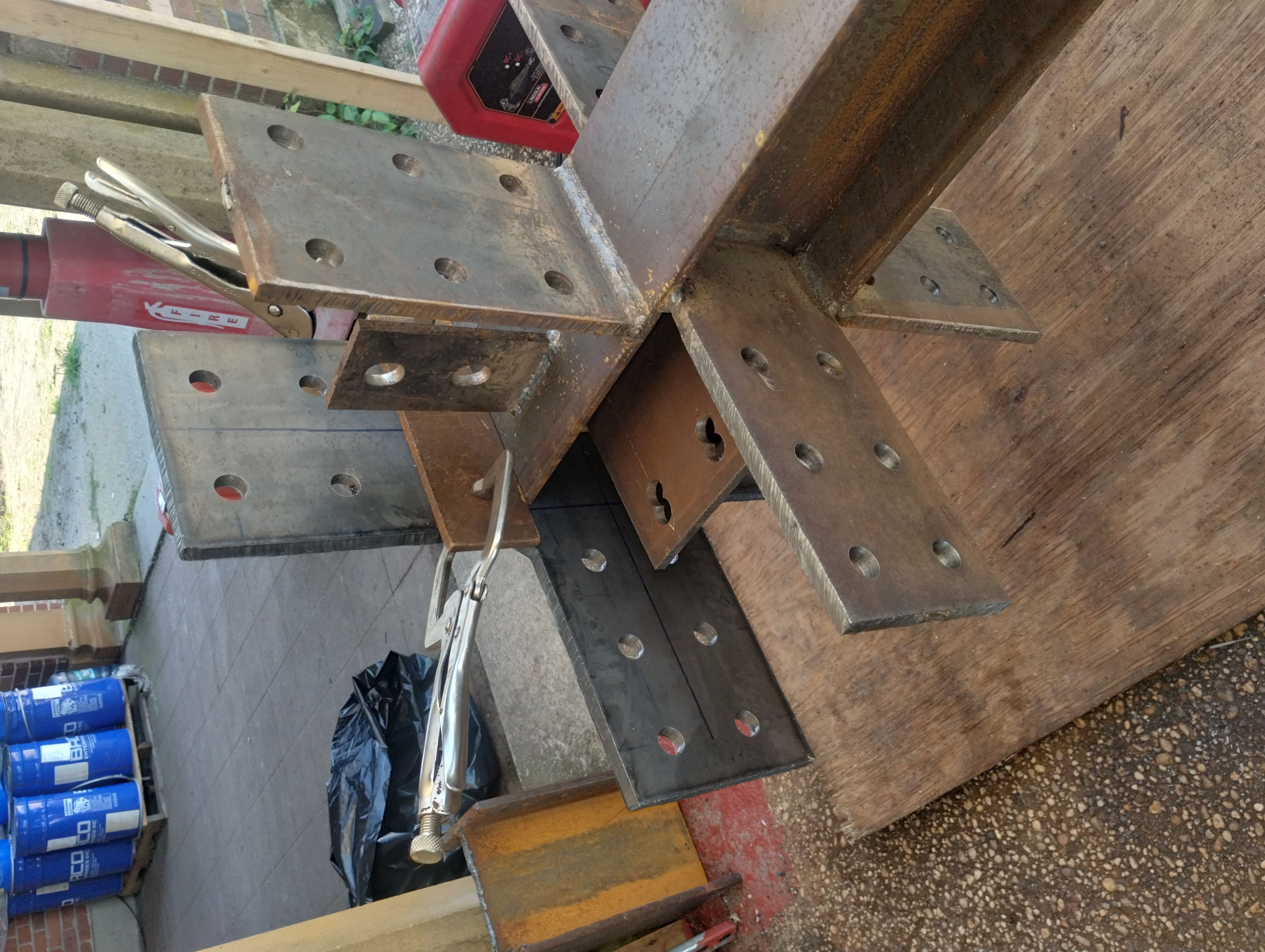 Steel connection plates with bolt holes clamped to a beam assembly