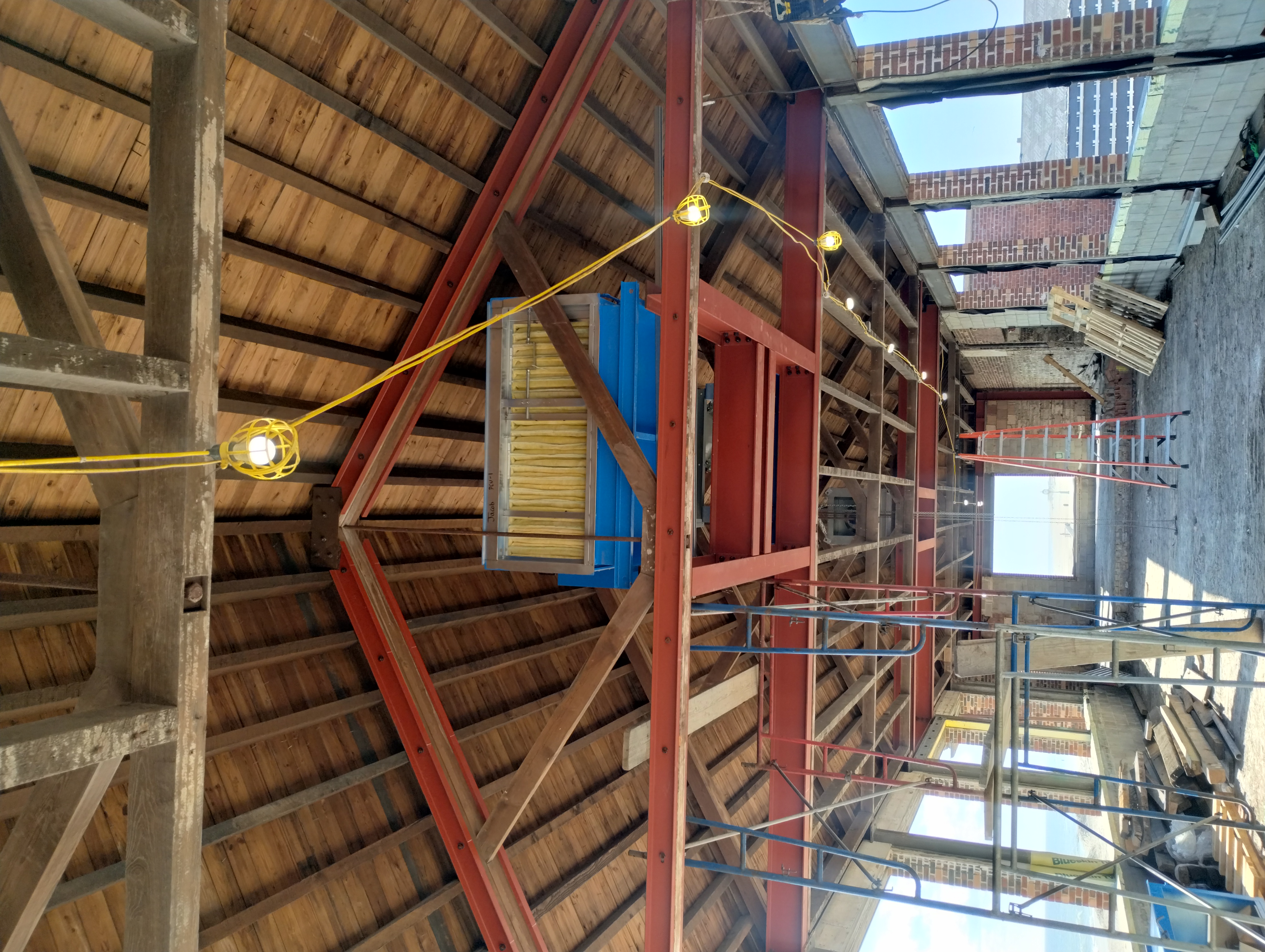 Steel support beams beneath mechanical equipment within a timber roof structure