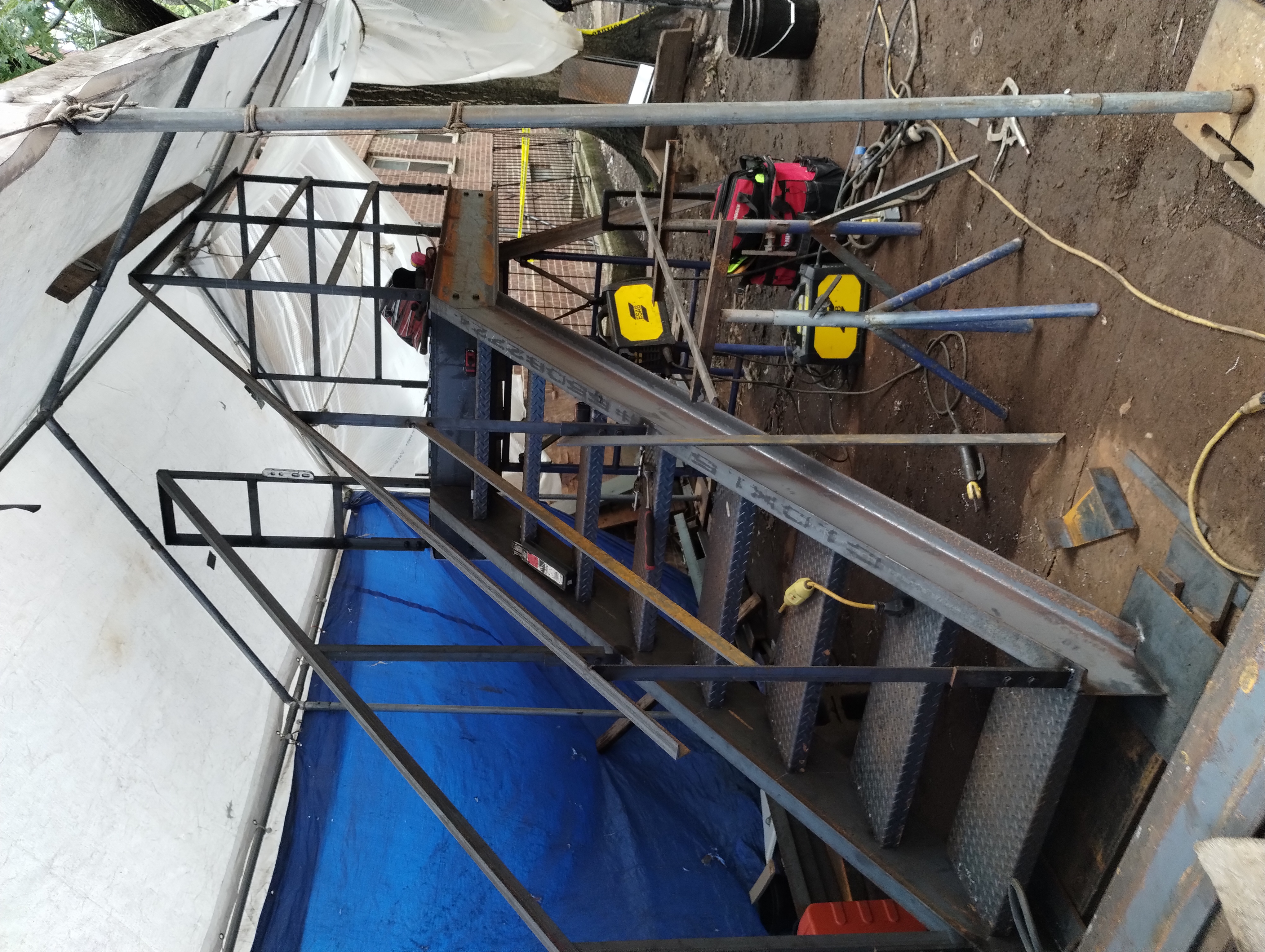Steel stair and landing assembly with railings under temporary site cover