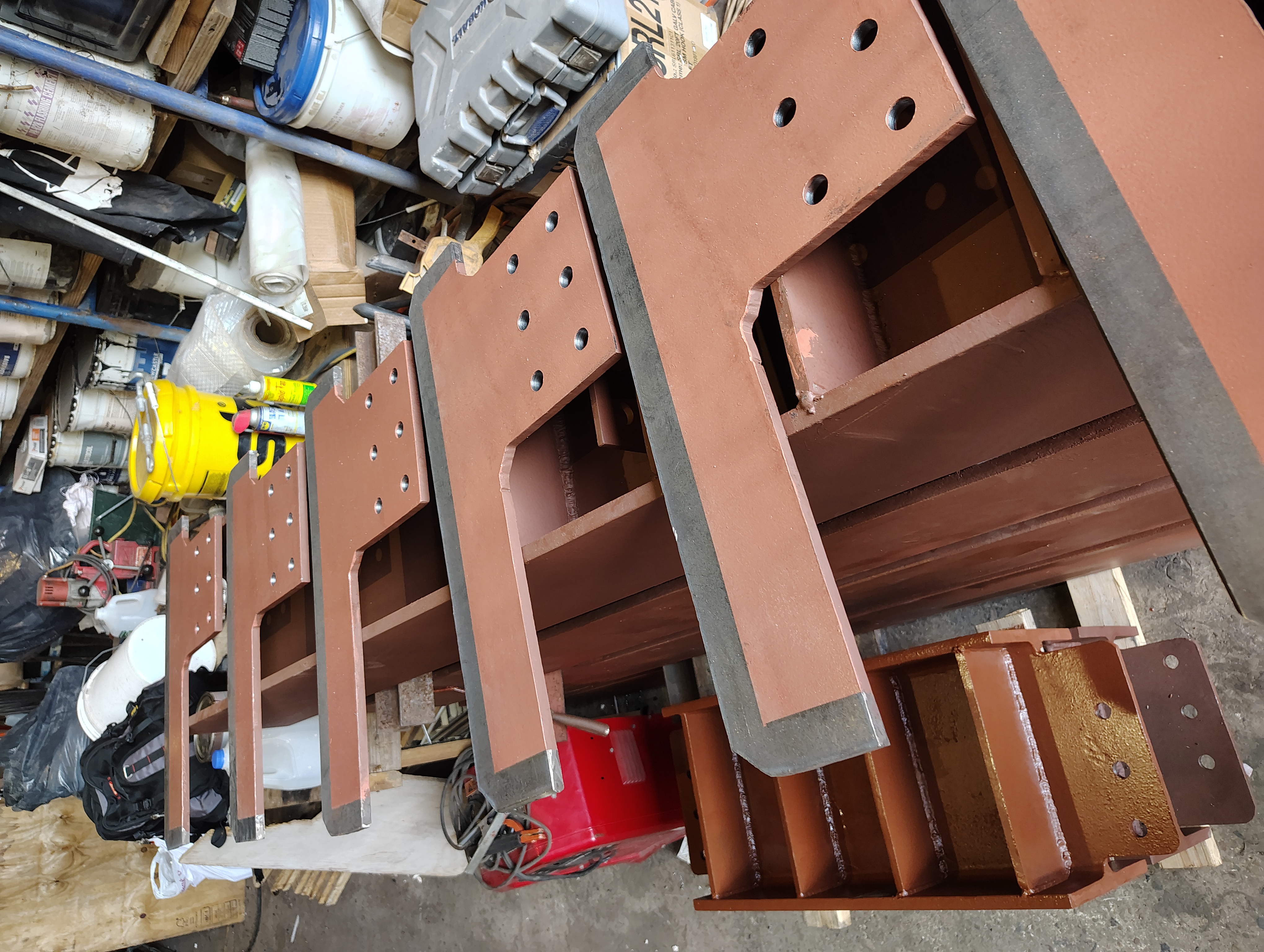 Shaped steel connection plates with drilled bolt holes and primer coating