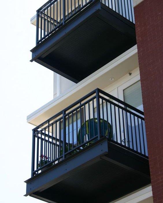 Black vertical-bar metal railings around two exterior balconies