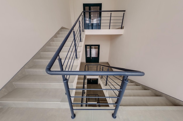 Steel handrails and horizontal railings around an interior stairwell