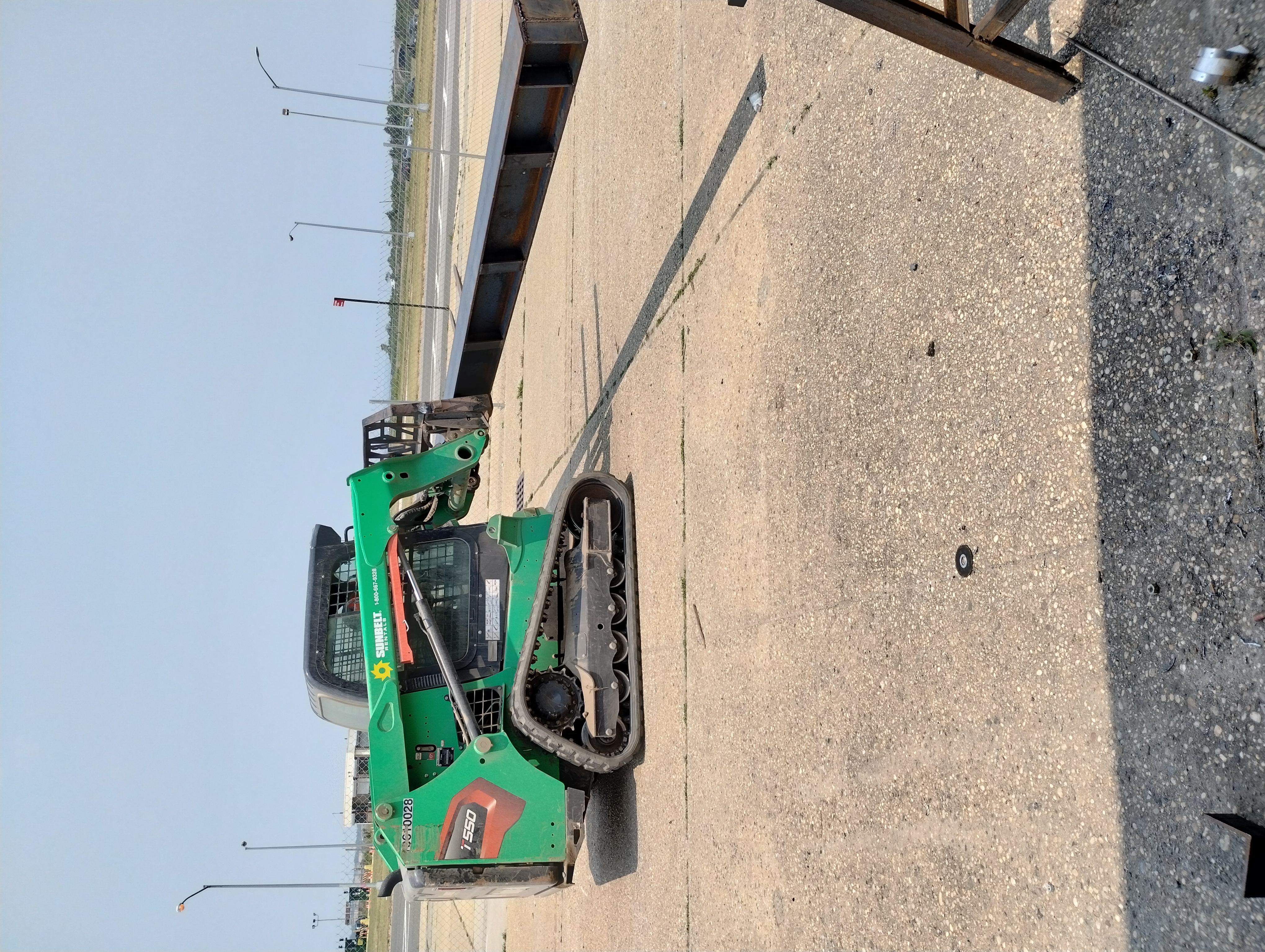 Compact loader moving a fabricated steel beam