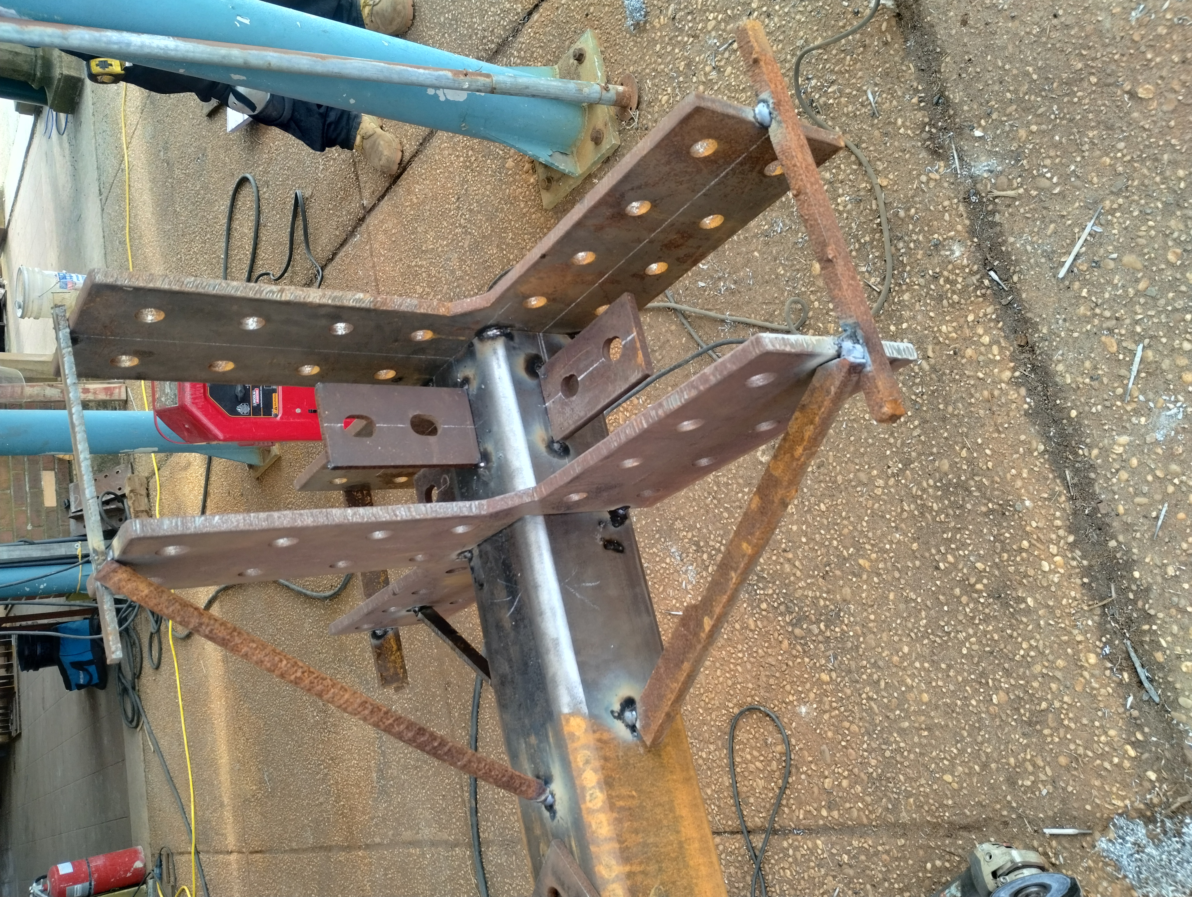 Drilled steel connection plates tack-welded in position on a steel member