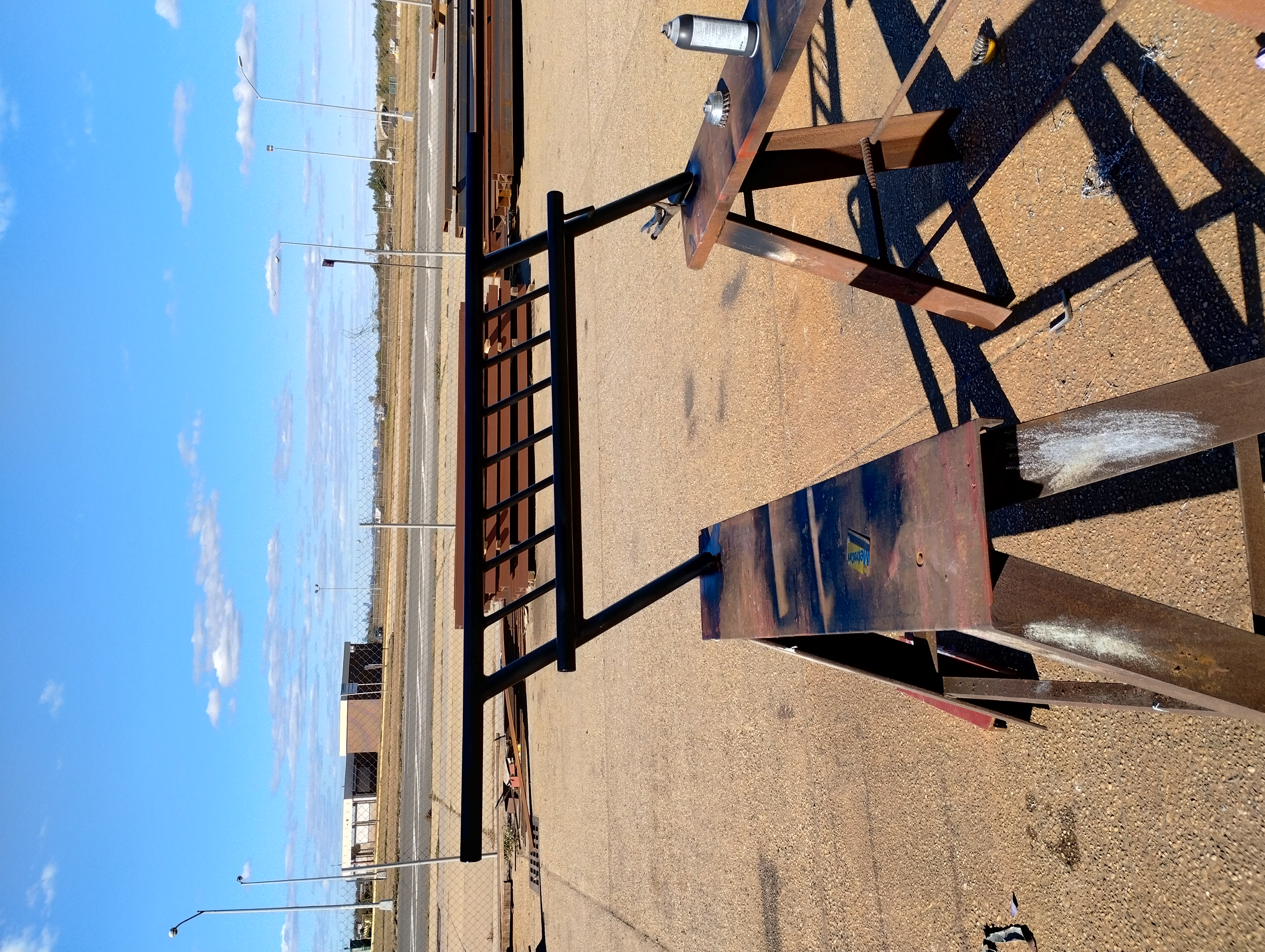 Black painted tubular steel railing section supported on work stands