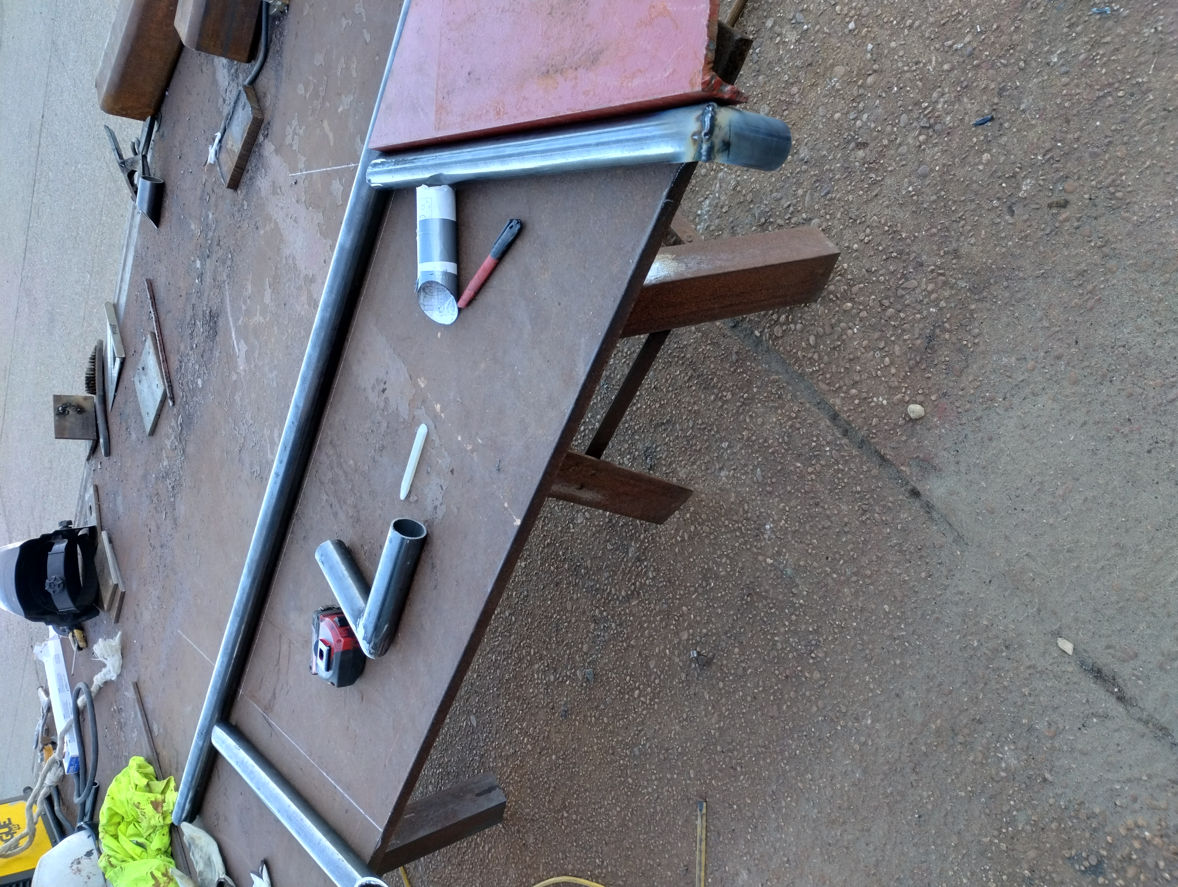 Tubular steel handrail components laid out and welded on a work table