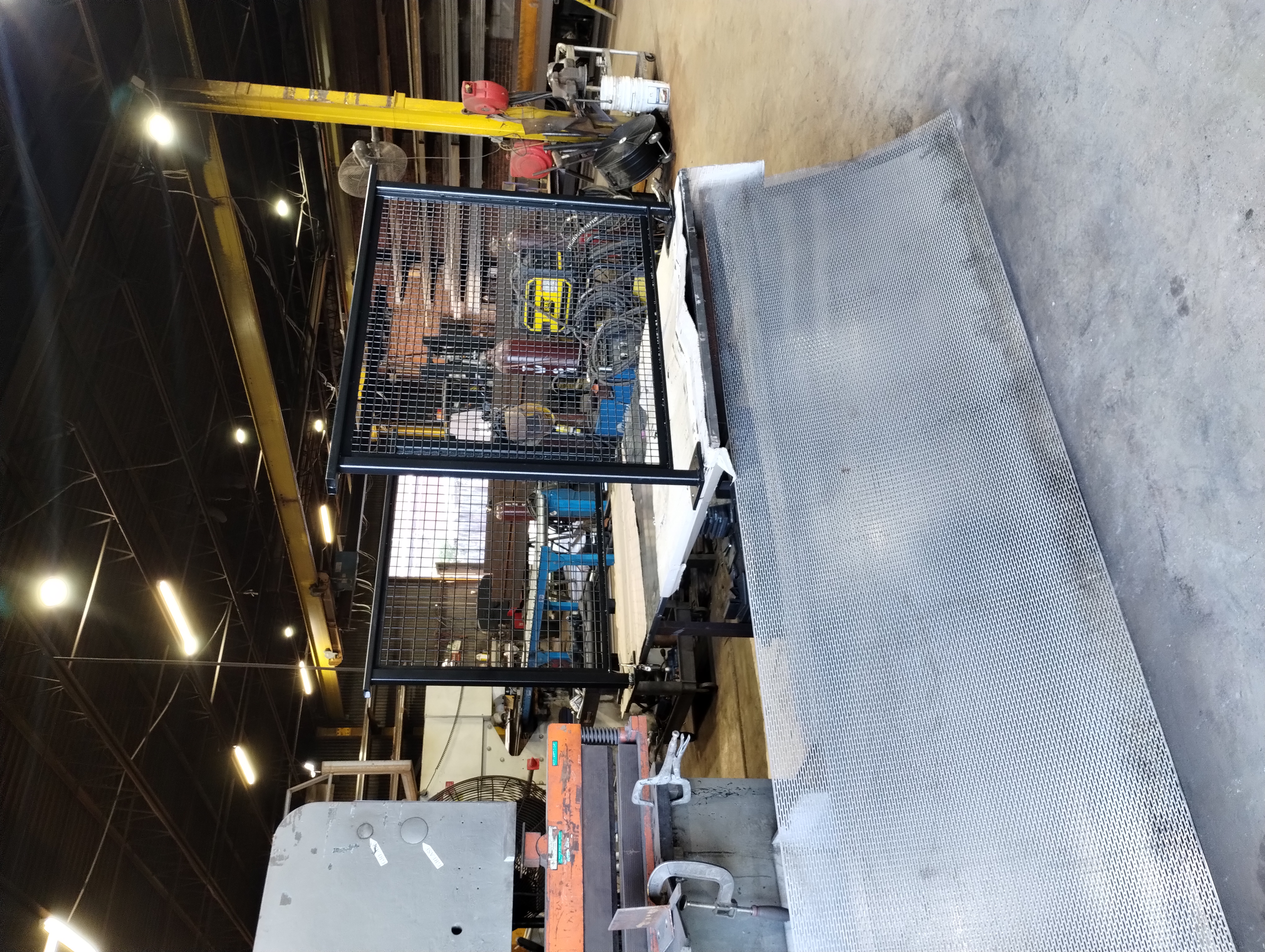 Black steel railing panels with square mesh infill in a workshop