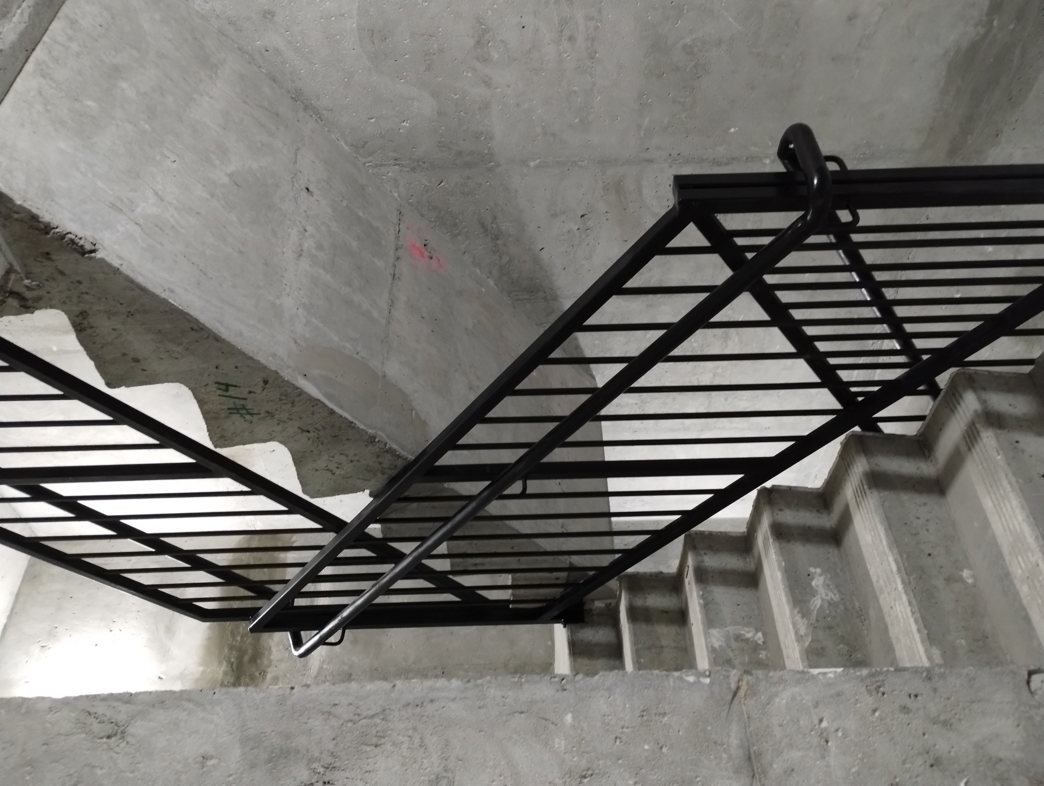 Black vertical-bar steel railings along concrete stairs