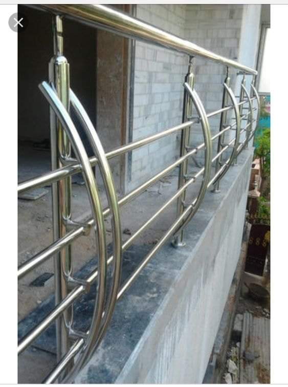 Polished tubular metal railing with curved posts and horizontal bars