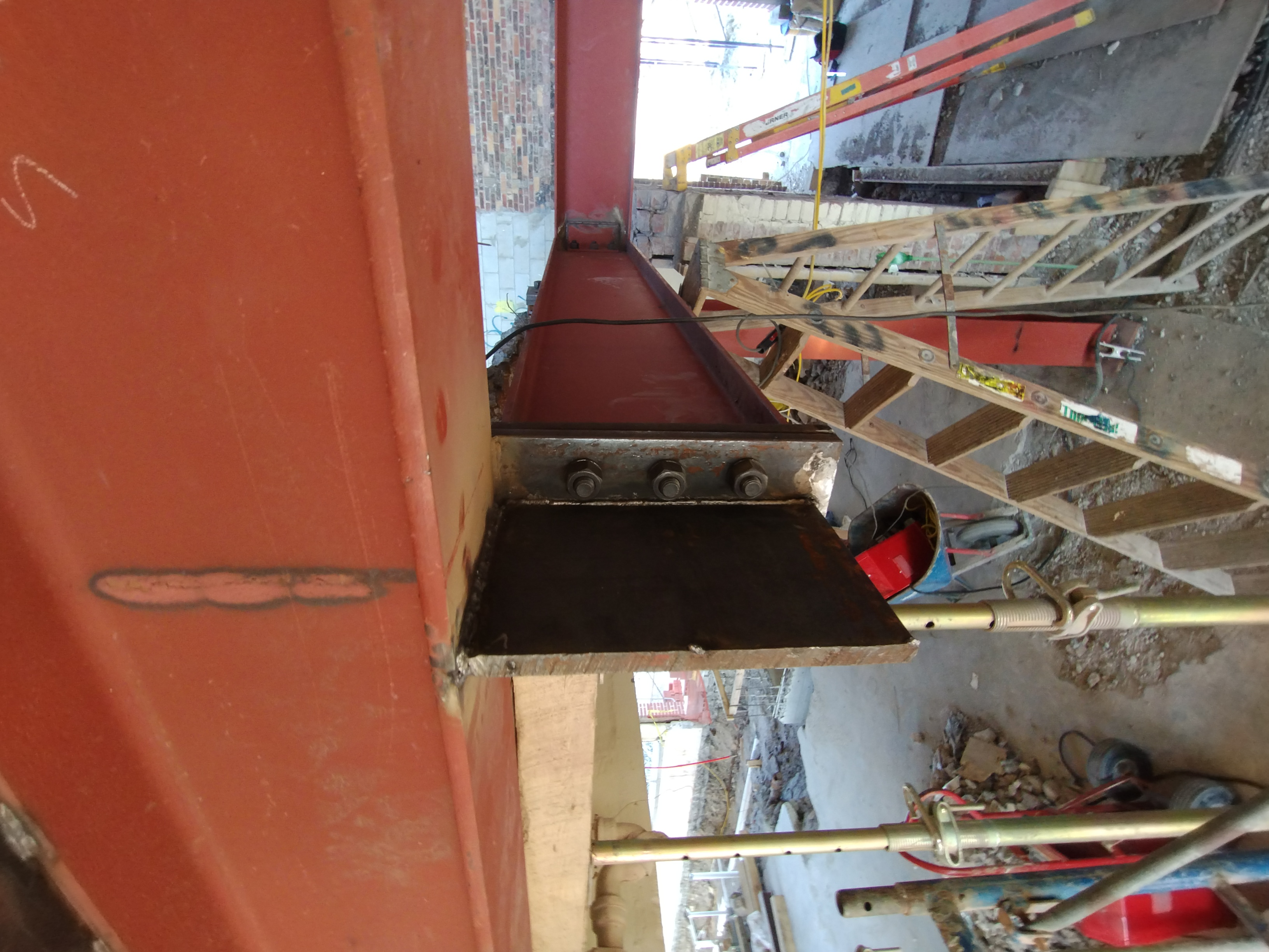 Close-up of a bolted steel beam connection within an existing building