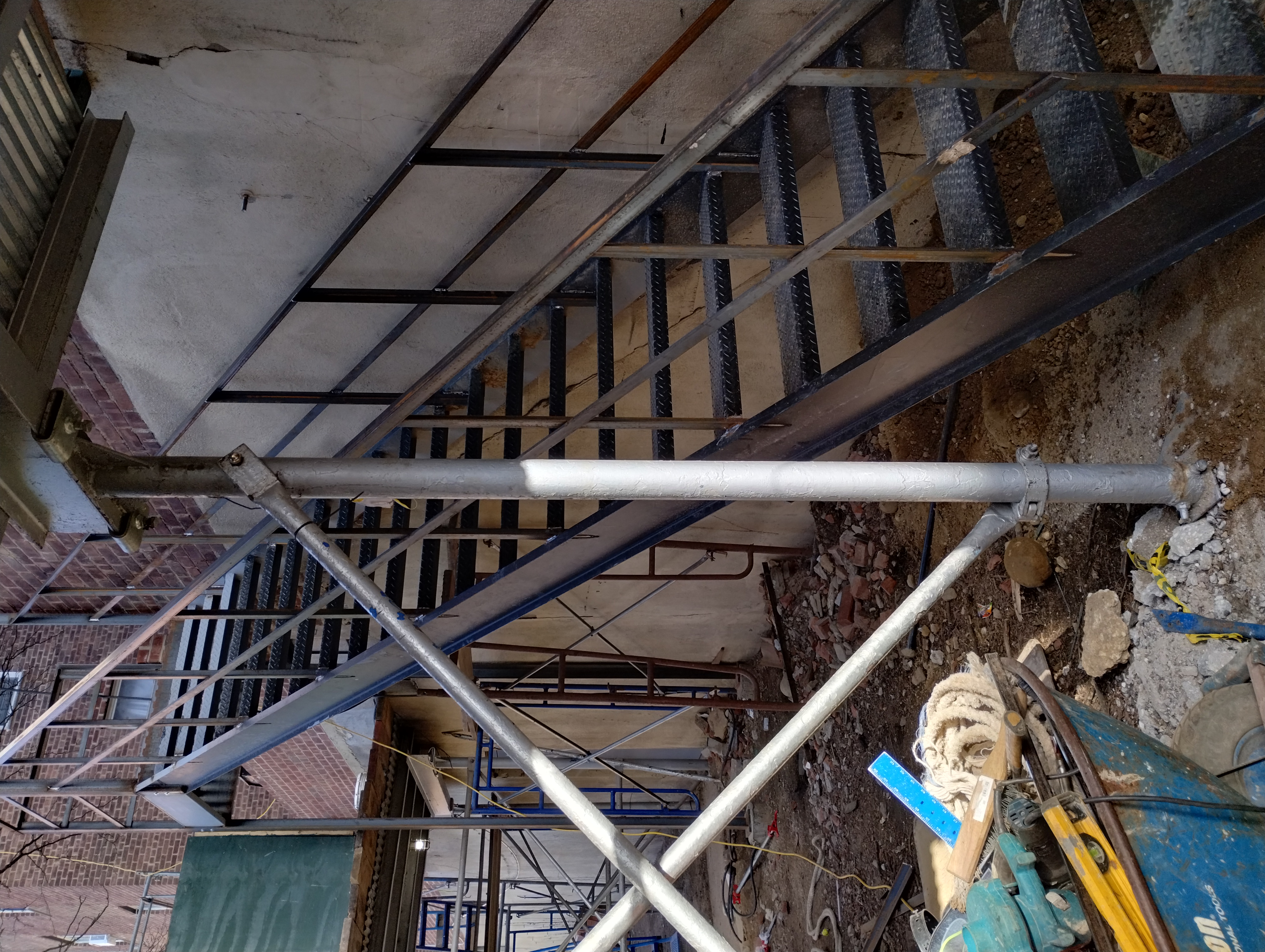 Steel staircase with railings during construction, viewed from the side