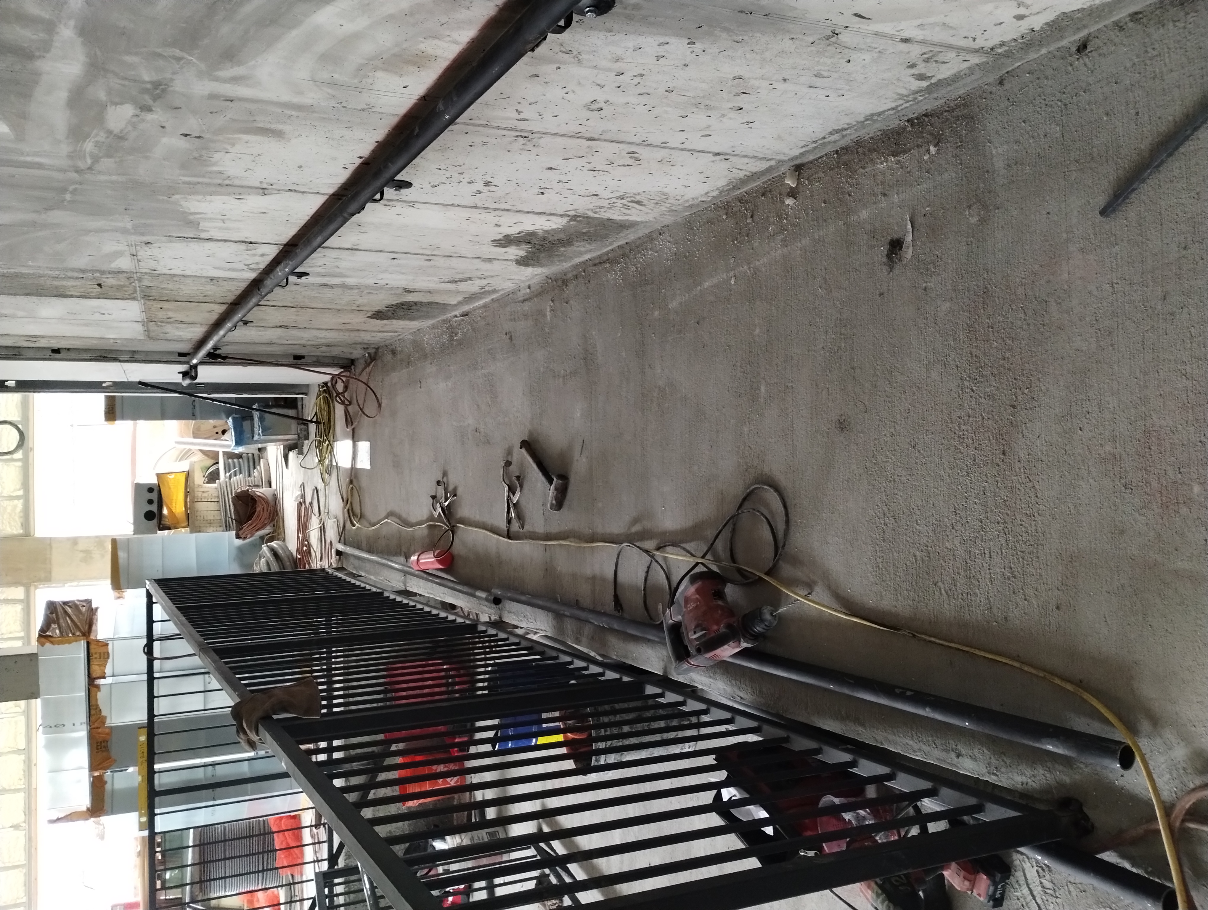 Black steel guardrail and wall-mounted tubular handrail during installation